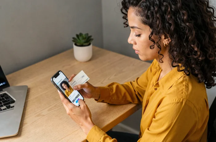 Femme utilisant son smartphone pour encaisser un chèque Carrefour en ligne